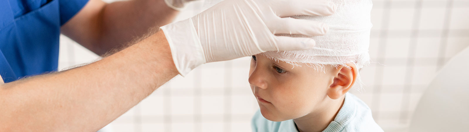 doctor-bandaging-kid-heads-1600x450